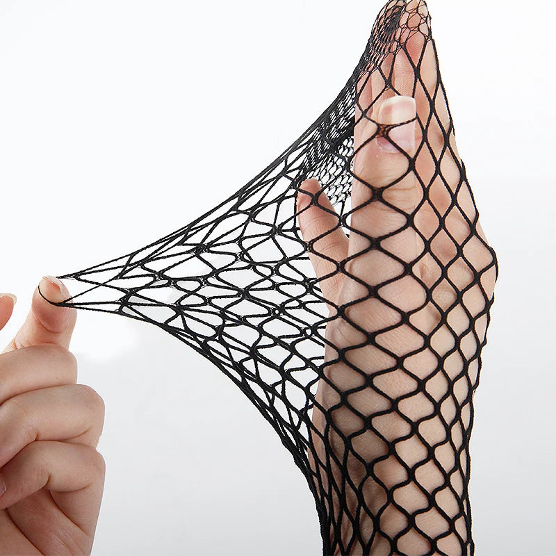 Black fishnet stocking held by a hand against a white background