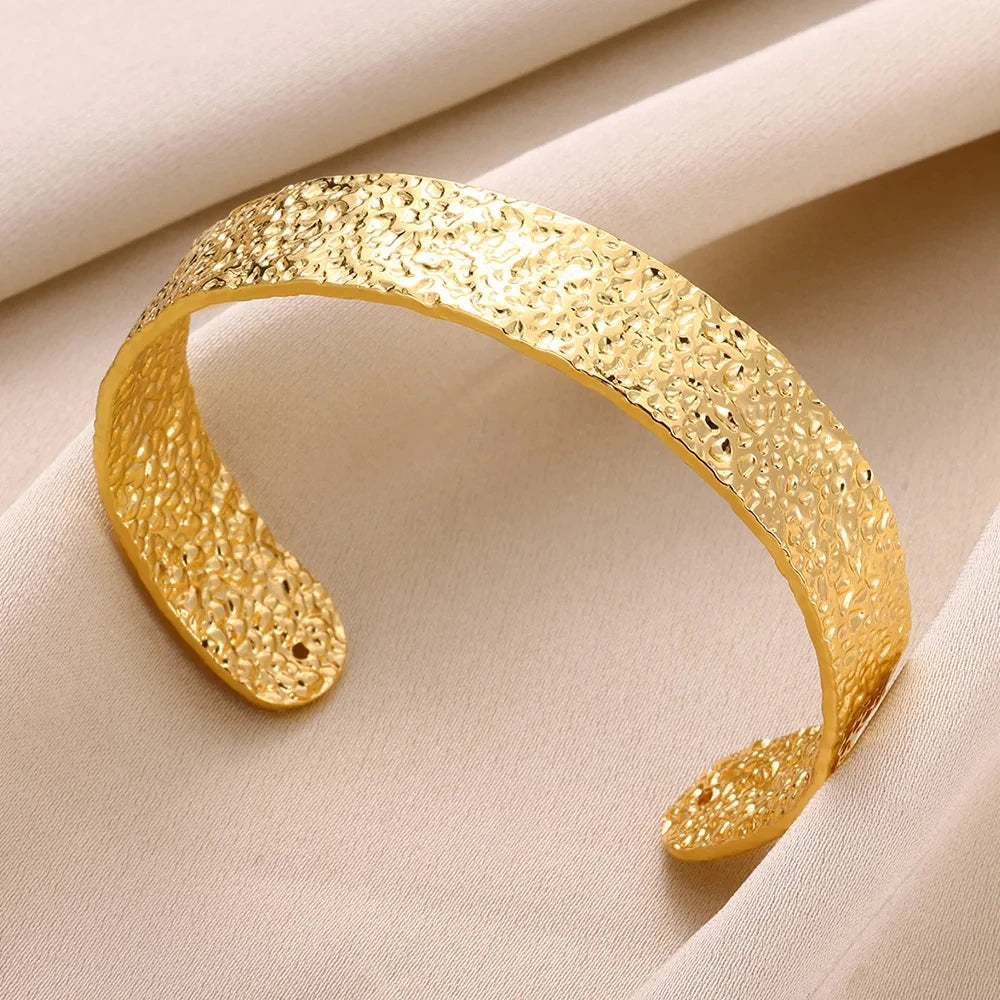 Gold bracelet on a beige fabric background