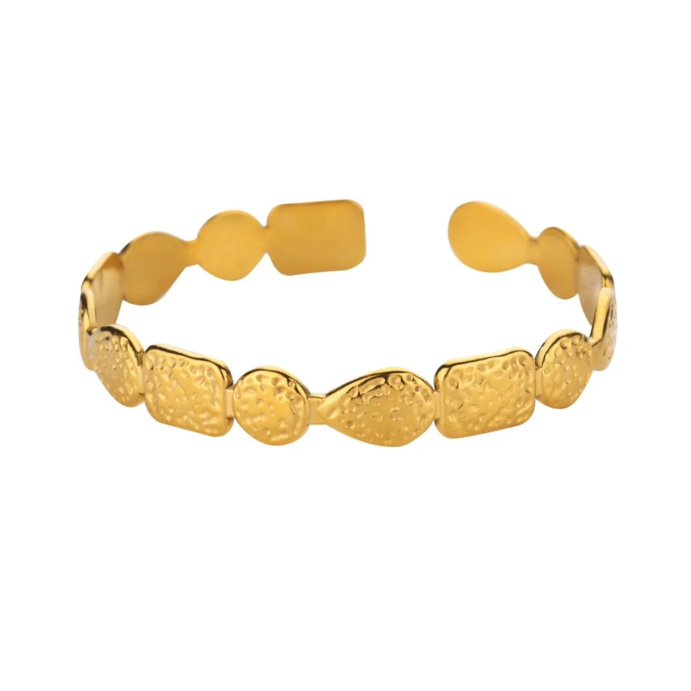 Gold bracelet with textured design on a white background