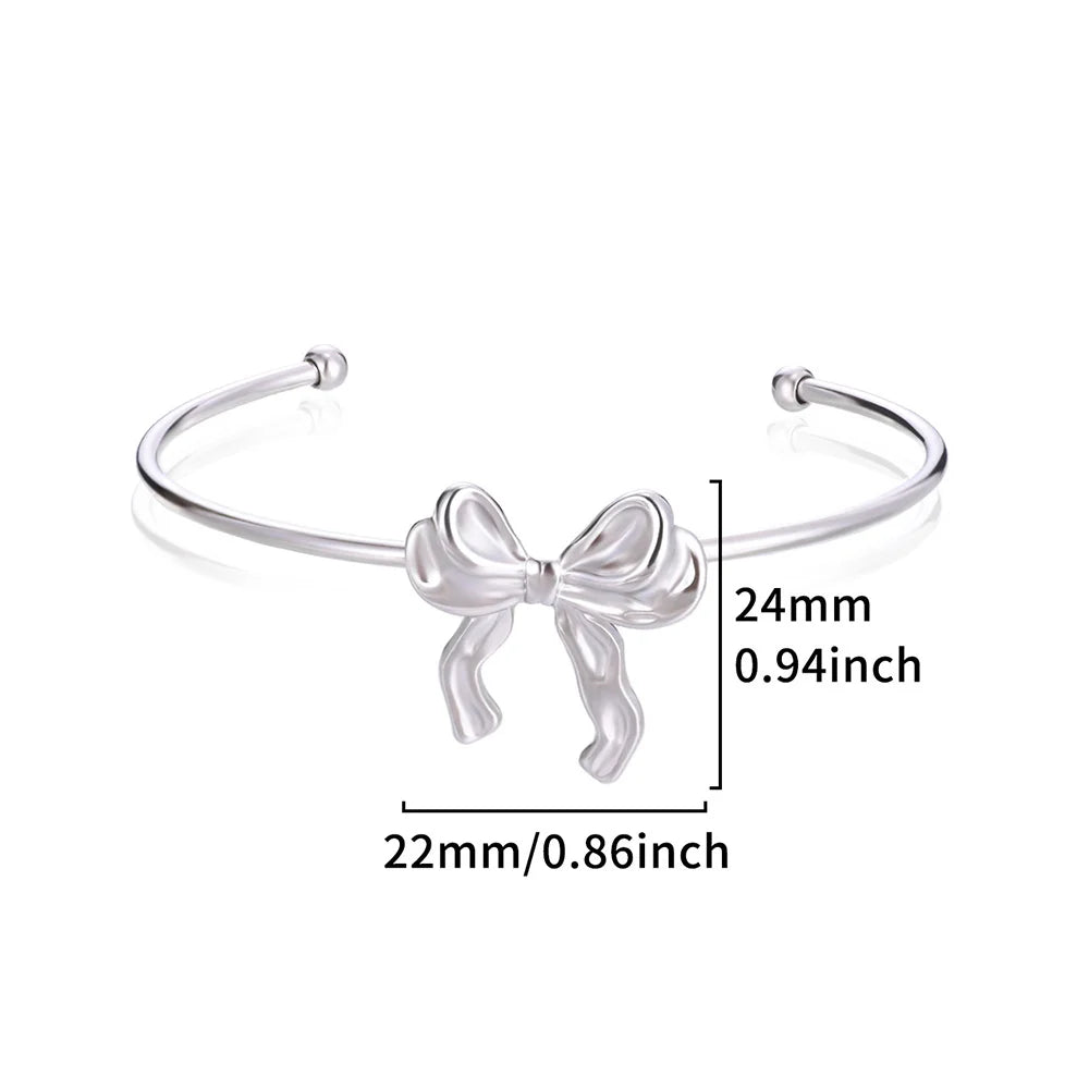 Silver bow-shaped bracelet with measurements on a white background
