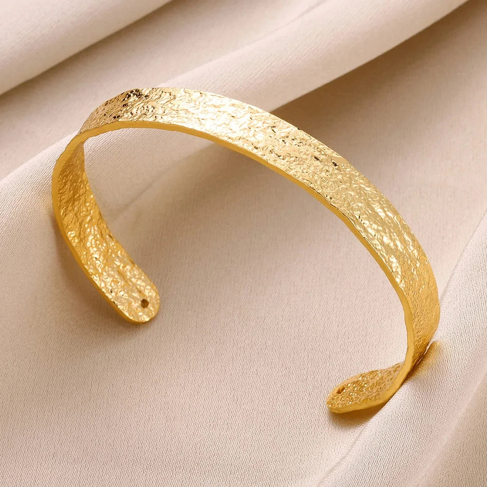 Gold bracelet on a beige fabric background