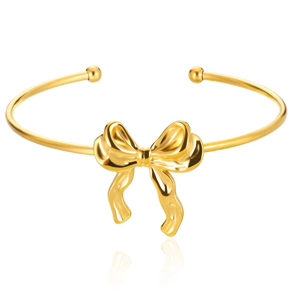 Gold bow-shaped bracelet on a white background